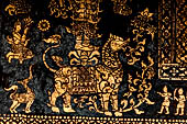 Wat Xieng Thong temple in Luang Prabang, Laos. Detail of the  intricate gold stencilling on black lacquer that decorate the walls of the sim. 